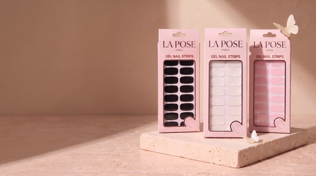 La Pose gel-strip cartons and an ivory butterfly on warm cream stone.